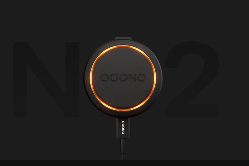 Der Ooono Co-Driver No2 leuchtet orange und ist an ein USB-C Ladekabel angeschlossen.